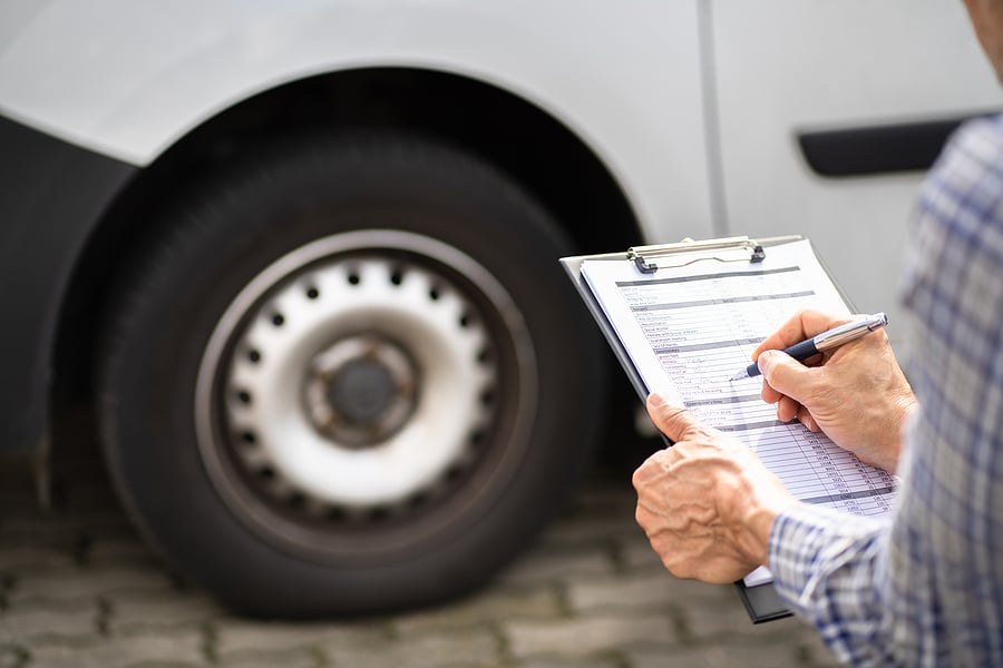Image of a person evaluating a vehicle for safety on Hollenshade's automotive services website