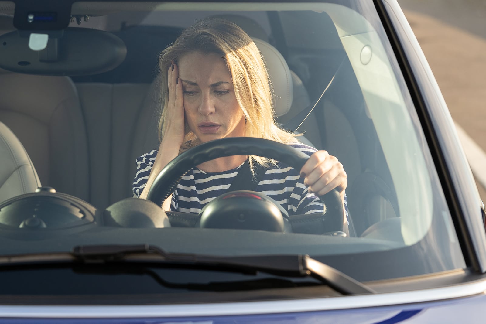 Image of a woman in a car looking concerned on Hollenshade's automotive services website