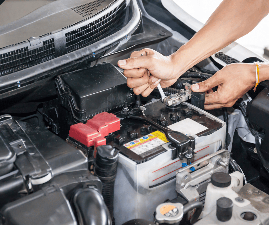 A mechanic replacing a car battery.
