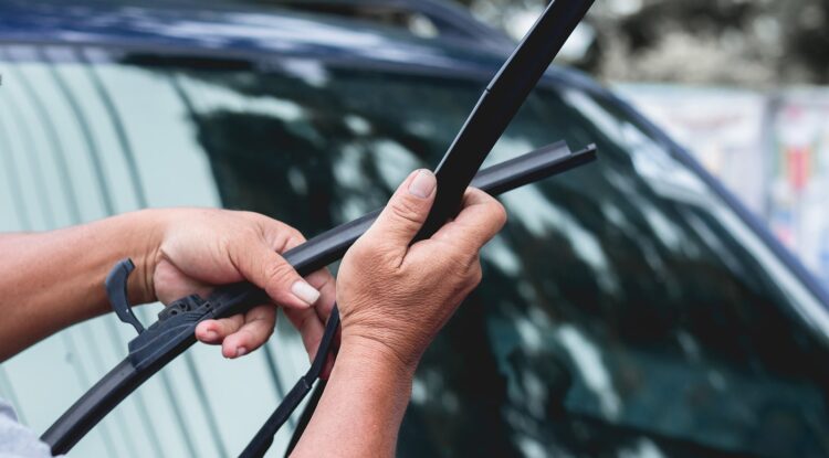 Mechanic fixing wiper blades on Hollenshade's automotive services website