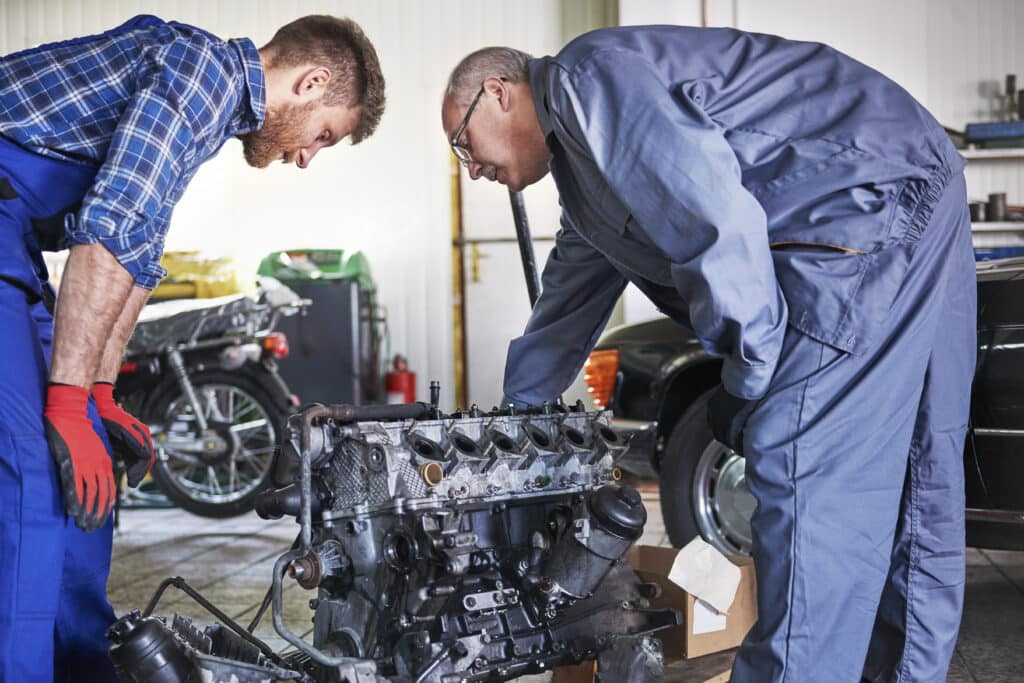 mechanics trying to repair car's engine